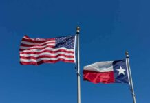American and Texas flags waving on flagpoles