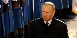 Vladimir Putin walking past a guard of honor