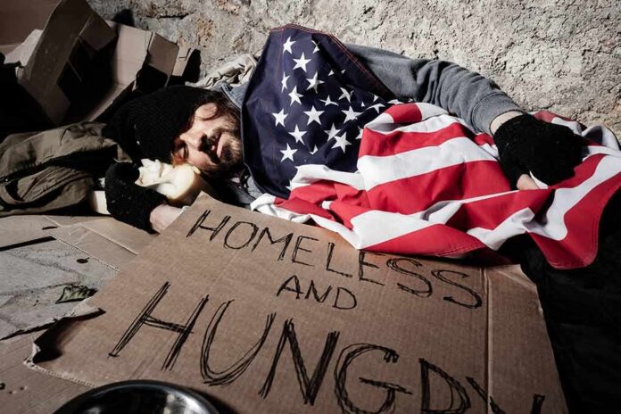 Homeless man sleeping on cardboard under an American flag