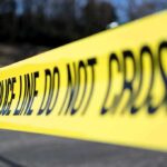 Yellow police tape stretched across an outdoor scene