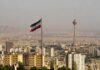 Iran Vows Pain – Trump Hints Something Bigger Iranian flag over Tehran skyline with Milad Tower
