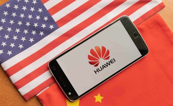 Smartphone displaying Huawei logo on U.S. and China flags