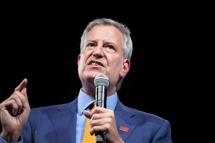 Bill de Blasio speaking into a microphone on stage