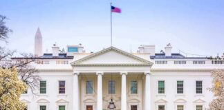 The White House facade with fountain and flag