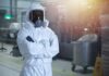 Worker in hazmat suit with respirator in industrial facility