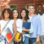 Group of students standing outdoors with notebooks