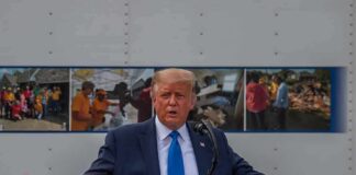 Donald Trump speaks at a podium with arms outstretched