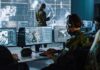 Military analysts at computers in a command center