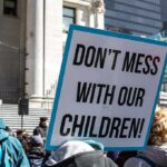 protest sign held in a crowd outside a government building