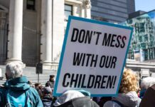 protest sign held in a crowd outside a government building