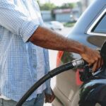 Person refueling a car at a gas pump