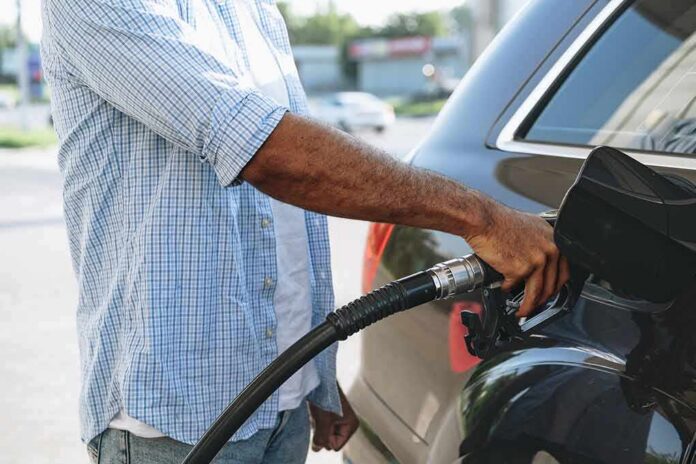 Person refueling a car at a gas pump
