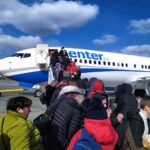 Rare Climbdown: Xi Puts Pastor On Plane Passengers boarding a commercial airplane via mobile stairs