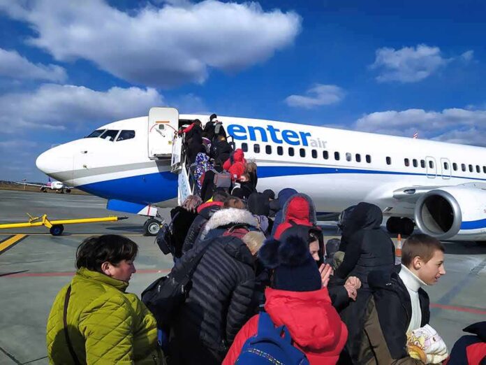 Passengers boarding a commercial airplane via mobile stairs