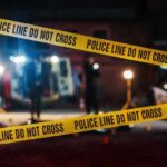 Police tape cordons off a dimly lit crime scene