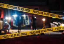 Police tape cordons off a dimly lit crime scene