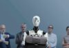 Humanoid robot holding a briefcase among seated job applicants