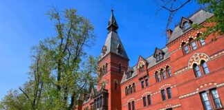 Campus Scandal Escalates: Shocking Chats Emerge Historic red brick building with tower on a sunny day