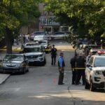 Enchilada Argument Ends In Gunfire Police officers secure a residential street with patrol cars and yellow tape