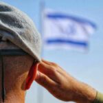 Soldier saluting with a blurred flag in the background