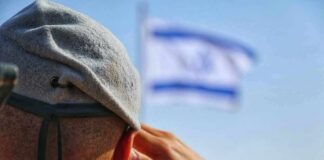 Soldier saluting with a blurred flag in the background