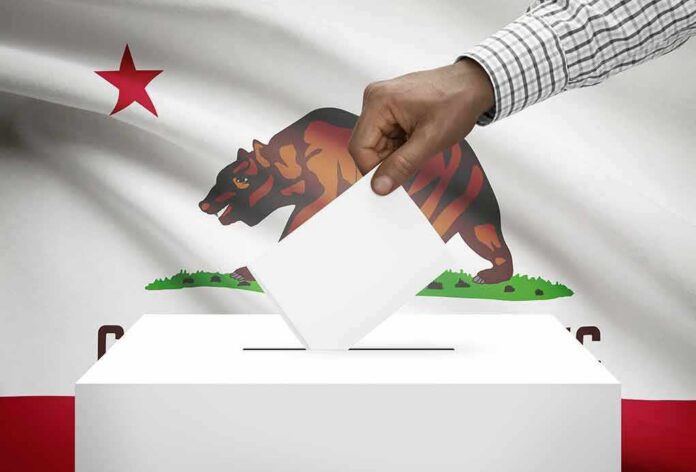 Hand casting a ballot into a box in front of the California flag