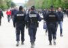 Police officers walking through a crowded park