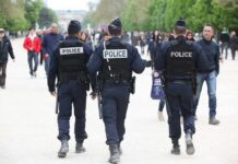 Police officers walking through a crowded park