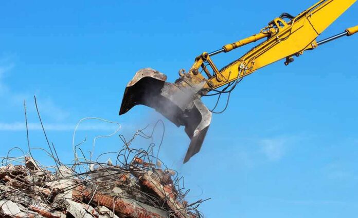 Excavator arm sorting rubble and rebar