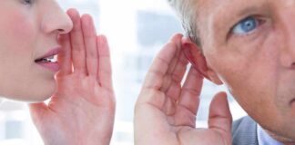 Woman whispering to a man's ear