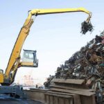 Material handler lifting scrap metal at a junkyard