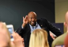 Tim Scott cupping his ear while interacting with a crowd