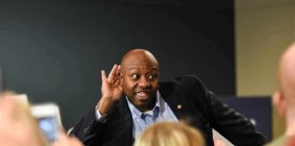 Tim Scott cupping his ear while interacting with a crowd