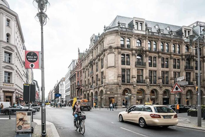 Busy city street with cyclist, taxis, and ornate historic building
