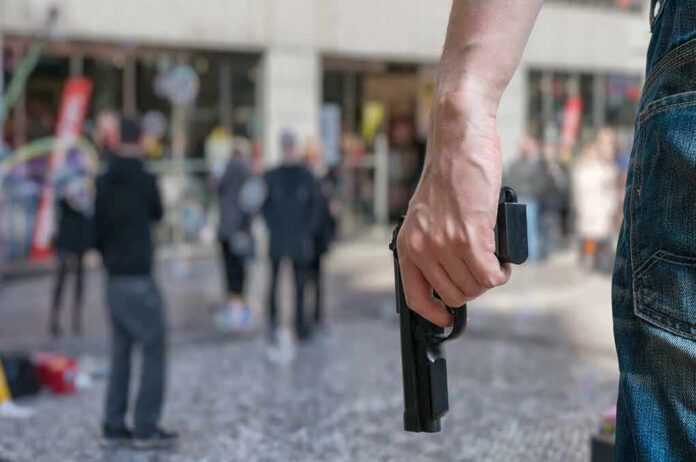 Person holding a handgun in a crowded public area