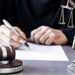 Blue States Defy DOJ — Hollywood on Trial Judge writing at desk with gavel and Lady Justice statue