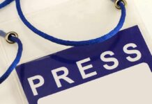 Press badge with blue lanyard