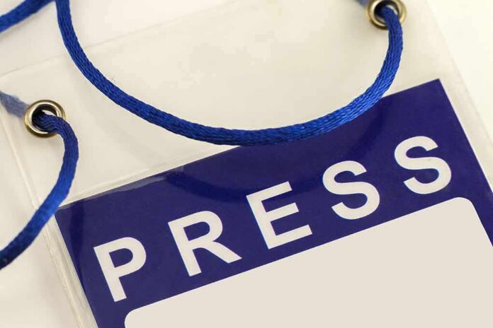 Press badge with blue lanyard