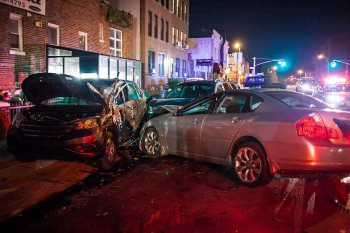 two cars collide on a city street at night