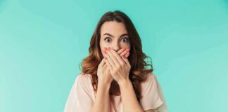 woman covering mouth with hands in surprise