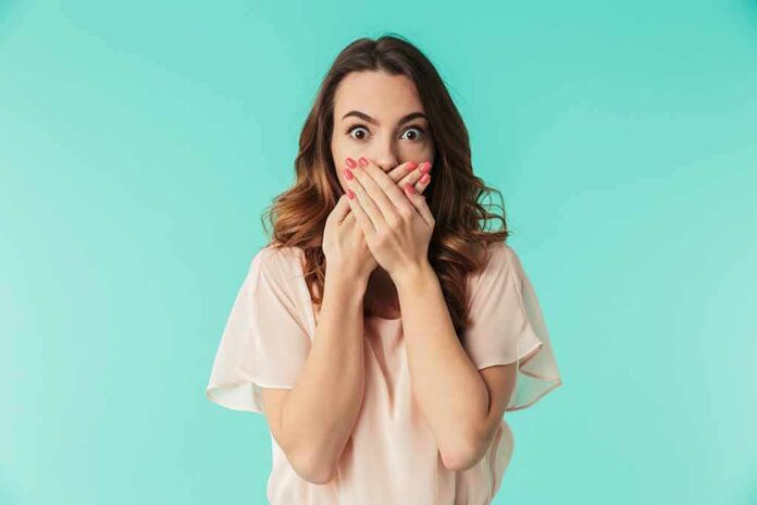 woman covering mouth with hands in surprise