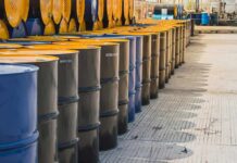 Rows of industrial metal barrels with yellow lids