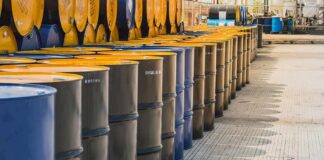 Rows of industrial metal barrels with yellow lids