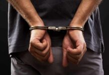 Burned Remains Found – Husband’s Story Crumbles person with hands cuffed behind back