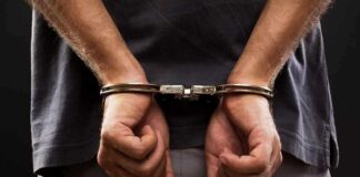 person with hands cuffed behind back