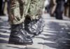 Row of soldiers in camouflage pants standing in formation with black boots