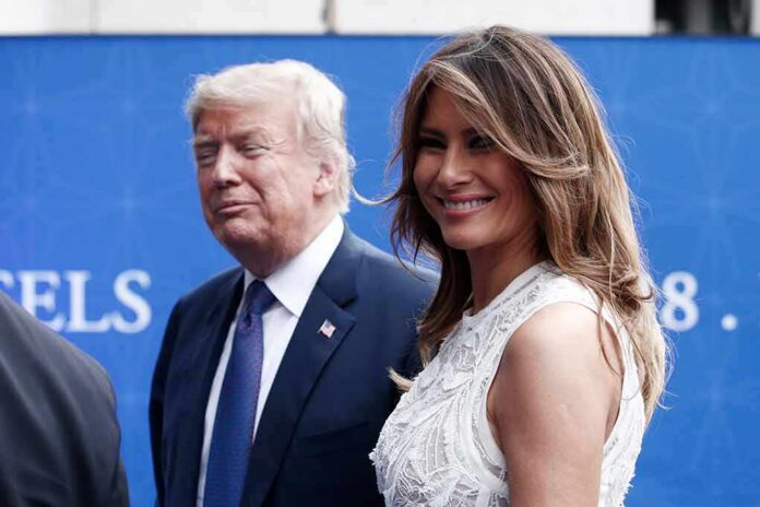 two adults at an event, one smiling in a white dress