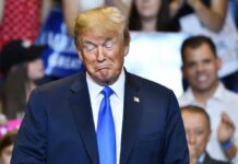 Donald Trump with eyes closed and pursed lips at an event