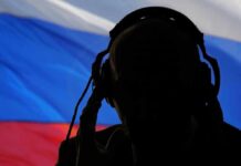 silhouetted person wearing headphones before a tricolor flag