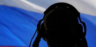 silhouetted person wearing headphones before a tricolor flag